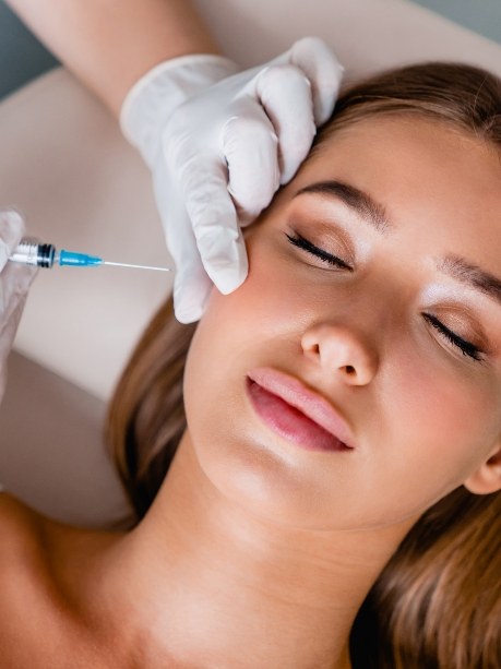 Woman with her eyes closed receiving an injection for Botox in Gorham