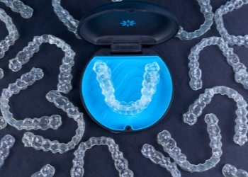 Several Invisalign clear aligners on table