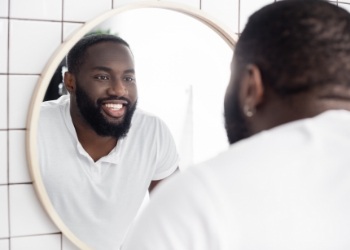 Man looking at his teeth in mirror