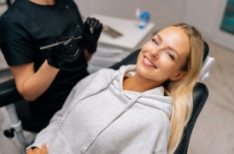 Blonde woman smiling and leaning back in dental chair