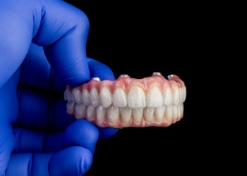 Dentist holding a set of implant dentures