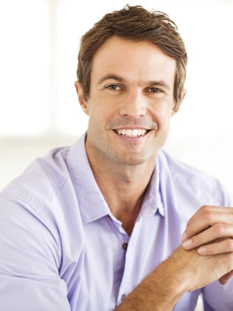 Man in lavender button down shirt smiling with tooth colored fillings in Gorham
