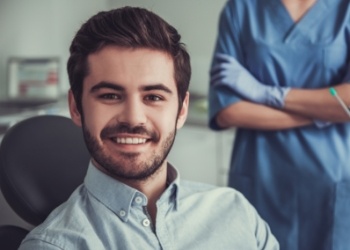 Young man with short beard smiling in dental chair