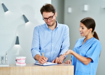 Dental team member showing a clipboard to a patient