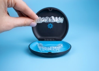 Hand placing Invisalign aligners in their storage case