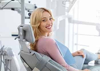 Blonde woman sitting in dental chair smiling