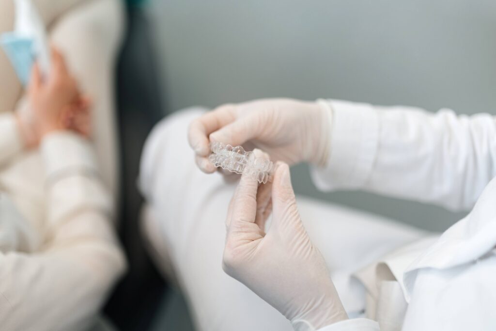 Closeup of dentist holding clear aligners