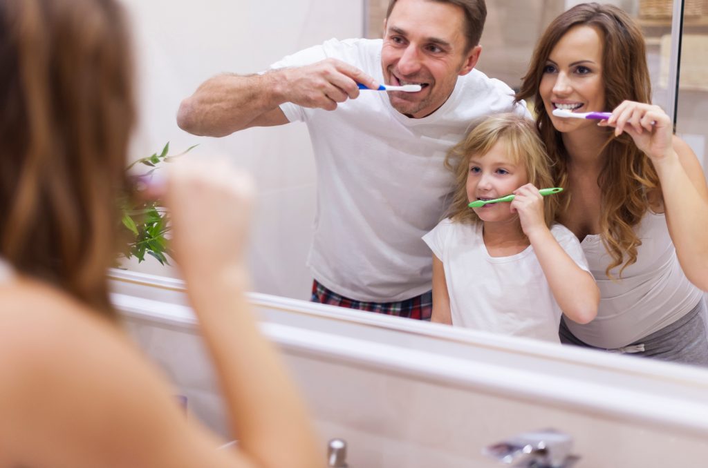 Family brushing teeth together representing family dentistry at Morgan Dental Care in Gorham, ME